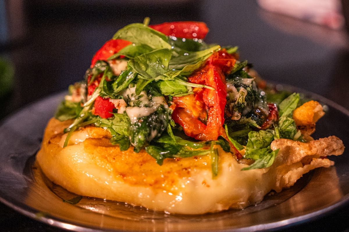 Provoleta con tomate, rúcula y pesto del bodegón de Club Kimberley