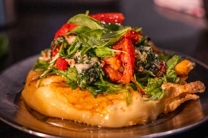 Provoleta con tomate, rúcula y pesto del bodegón de Club Kimberley