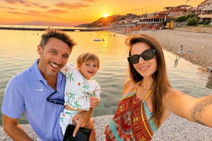 Pura felicidad. Diana y Juan, que tiene al pequeño León a upa, posan para una selfie en la playa cuando cae el sol
