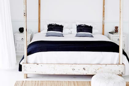 Pura ilusión: la madera de la cama con dosel se patinó para darle el efecto del desgaste marino, como un obsequio regalado por la marea.