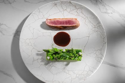 Puré de arvejas, menta y parmesano; una ensalada verde con un toque picante; y papas “bandoneón” acompañan al pato en Roux