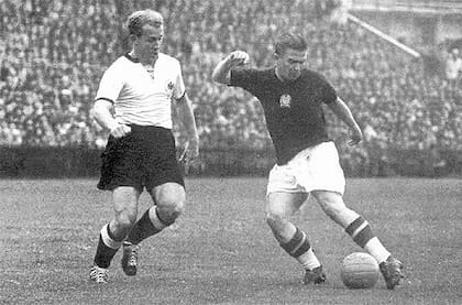 Puskas lleva la pelota ante la marca de un jugador de Alemania
