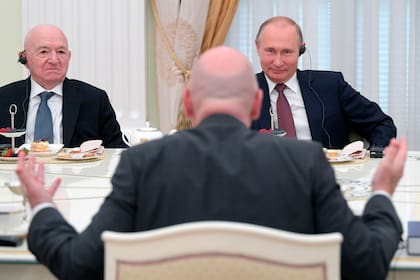 Putin escucha al presidente de la FIFA, Gianni Infantino; a su lado, el vicepresidente de la Federación Rusa de Fútbol Nikita Simonyan