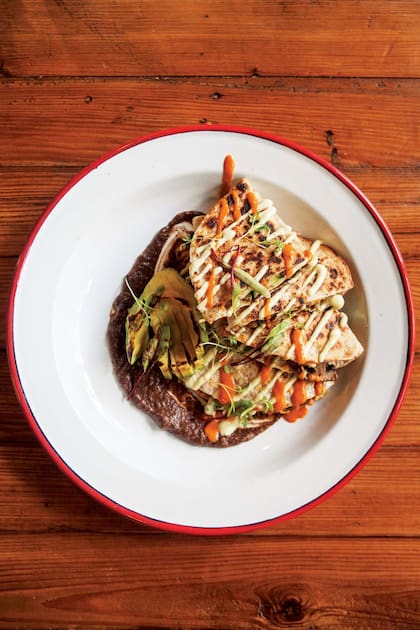 Quesadillas veggie: cheddar de cajú, champignon, zucchini, maíz y cilantro, con mole de porotos negros.