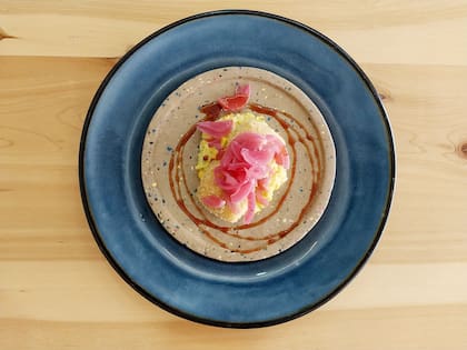 Queso brie empanado con frutos secos, humita norteña y pickles de cebolla morada.