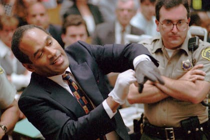 Quince de junio de 1995: OJ Simpson gesticula en un tribunal de Los Ángeles al ponerse los guantes que los fiscales aseguraron usó en la noche en que Nicole Brown y Ron Goldman fueron asesinados.
