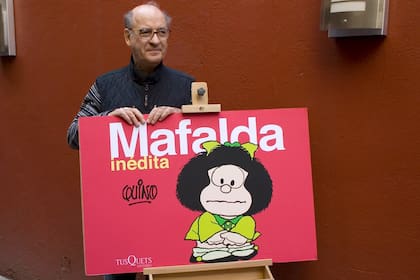 Quino y uno de los volúmenes que reúne su material inédito