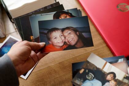 Rachel Taylor mira fotos de ella con su hijo Kyle Domrese, el 17 de noviembre de 2021, en su casa en Bemidji, Minnesota. Kyle Domrese fue uno de muchos indígenas norteamericanos que murieron por sobredosis en medio de la pandemia. (AP Foto/David Goldman)