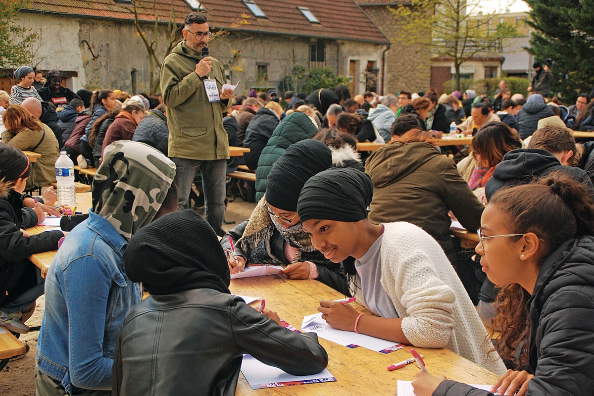 Rachid Santaki dicta y gente de todas las edades escribe a mano