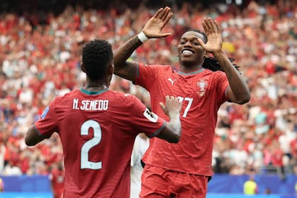Rafael Leão festeja con Nelson Semedo, luego de cerrar la goleada para Portugal