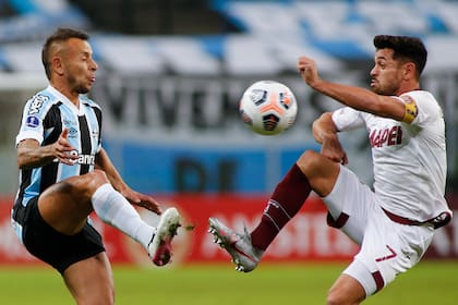 Rafinha of Brazil's Gremio, left, and Lautaro Acosta of Argentina's Lanus battle for the ball during a Copa Sudamericana soccer match in Porto Alegre, Brazil, Thursday, May 13, 2021. (Silvio Avila/Pool via AP)