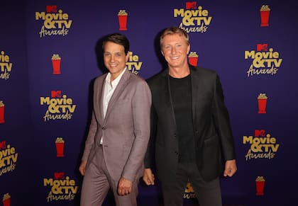 Ralph Macchio y William Zabka, sonrientes, aunque con las manos vacías