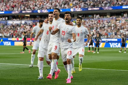 Ramin Rezaeian (23), autor del primer gol de Irán, celebra con el Saeid Ezatolahi (6) y el capitán Mehdi Taremi; la séptima participación en los mundiales de los iraníes, entre la tensión y el juego