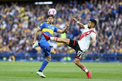 Ramírez lucha por la pelota con Paulo Díaz; Boca se adueñó de un superclásico áspero
