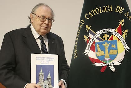Ramón Gutiérrez con un ejemplar de uno de sus libros, "Evolución histórica urbana de Arequipa. 1540-1990"