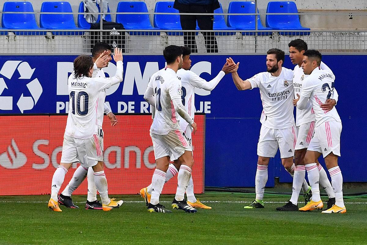 Raphael Varane, del Real Madrid, celebra con sus compañeros tras marcar un segundo gol durante el partido de fútbol de la liga española entre la SD Huesca y el Real Madrid en el estadio El Alcoraz de Huesca el 6 de febrero de 2021.
