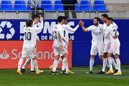 Raphael Varane, del Real Madrid, celebra con sus compañeros tras marcar un segundo gol durante el partido de fútbol de la liga española entre la SD Huesca y el Real Madrid en el estadio El Alcoraz de Huesca el 6 de febrero de 2021.