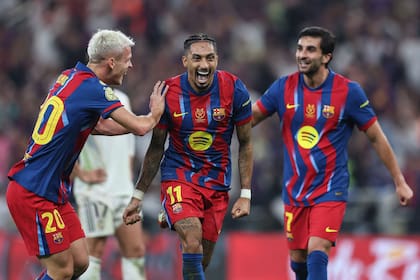 Raphinha, autor de dos goles en la final, festeja entre Olmo y Ferrán Torres la definición del 3-2