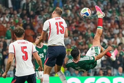 Raúl Jimenez intenta una pirueta en el área, pero la pelota dará en la espalda de Burn (AP Photo/Natacha Pisarenko)