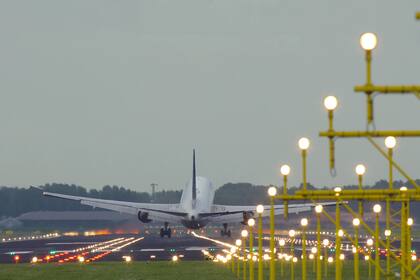 Rear view of Boeing of Unnited Airlines landing at Schiphol airport at sunset. Shot from the beginning of runway.