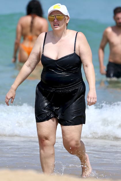Rebel Wilson disfrutó de Bondi Beach con su pareja Ramona Agruma. La actriz australiana decidió aprovechar el día de calor para darse un chapuzón en el mar de una de las playas más famosas de Sídney. Para la ocasión, la actriz lució una malla enteriza negra y un short del mismo color, que combinó con lentes espejados amarillos y una gorra para protegerse del sol. Wilson se dejó ver despreocupada en la playa apenas unos días después de realizar un posteo en sus redes sociales para hablar, sin vueltas, de su reciente aumento de peso. "Me hace sentir mal conmigo misma, no debería... pero lo hace", se sinceró y explicó que por centrarse en el trabajo perdió de foco el “estilo de vida saludable”