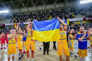 Recién derrotados en Córdoba, los jugadores ucranios muestran una bandera de su país y aplauden al público español, que les retribuye con el reconocimiento a haber jugado en baja condición anímica por la eliminatoria europea para el Mundial.
