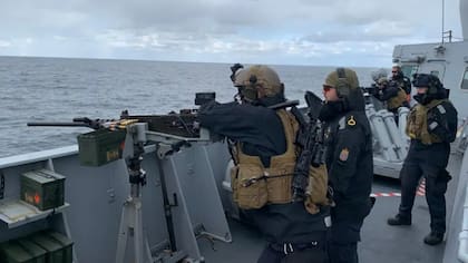 Reclutas y oficiales participando en un ejercicio de tiro real a bordo del barco noruego Otto Sverdrup.