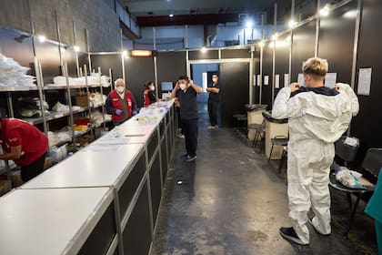 Los voluntarios que trabajan en el Parque Sanitario Tecnópolis, se preparan para entrar a la Zona Roja, donde están los pacientes con coronavirus