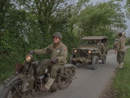 Recreadores vestidos y equipados como en la Segunda Guerra Mundial durante un tour histórico en Normandía