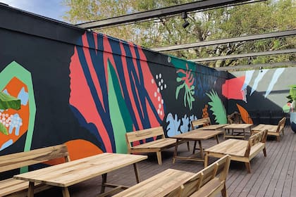 Rectas y curvas se combinan y recrean fragmentos de distintos elementos de la naturaleza, en este mural realizado por el artista Darío Parvis sobre las paredes perimetrales del patio del restaurante Enero.
