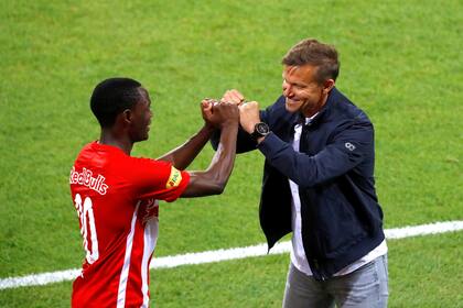 El delantero zambiano de Salzburg Patson Daka saluda a su entrenador, el estadounidense Jesse March, respetando el protocolo por el coronavirus, en la final por la Copa de Austria, que el equipo rojo ganó al imponerse por 5-0 a Austria Lustenau.