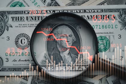 Red down arrow inside of magnifier glass and USD dollar banknote for United States of America or USA economic recession crisis and Fed reduce interest concept.