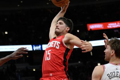 Reed Shepard (15), de los Rockets de Houston, se alza para retacar el balón en el aro ante la mirada de Matas Buzelis (14) y Dalen Terry (25), de los Bulls de Chicago, durante la segunda mitad del juego de baloncesto de la NBA, el domingo 17 de noviembre de 2024, en Chicago. (AP Foto/Paul Beaty)