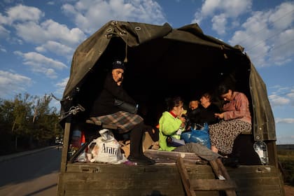 Refugiados provenientes de Nagorno Karabaj se sientan en un camión cargado con sus pertenencias cerca de Kornidzor el 28 de septiembre de 2023.