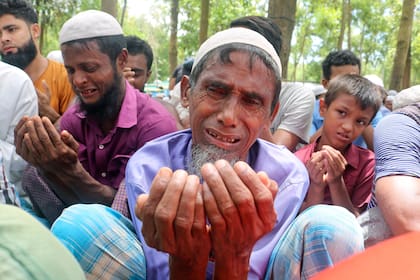 Refugiados rohingia lloran y oran durante una reunión en el quinto aniversario de su éxodo de Myanmar a Bangladesh, en el campamento de refugiados Kutupalong, distrito de Cox's Bazar, Bangladesh, jueves 25 de agosto de 2022.  (AP Foto/ Shafiqur Rahman)