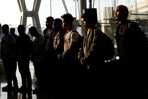 Rehenes tailandeses que fueron liberados por Hamás guardan un minuto de silencio a su llegada al Aeropuerto Internacional Suvarnabhumi, en la provincia de Samut Prakarn, Tailandia, el jueves 30 de noviembre de 2023. (AP Foto/Sakchai Lalit)