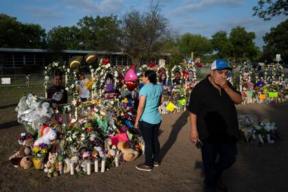 Rene Lucero y su esposa Alva visitan un sitio de homenaje tras el tiroteo en la Escuela Primaria Robb en Uvalde, Texas, el martes 31 de mayo de 2022. (AP Foto/Jae C. Hong)