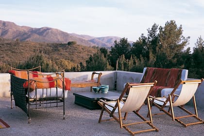 Reposeras, mesa ratona y banco de madera completan la terraza