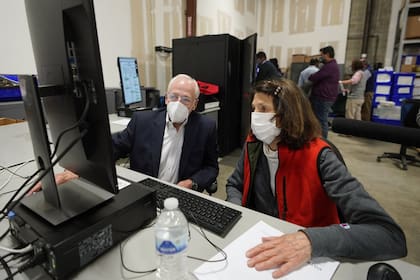 Representantes demócratas y republicanos revisan las boletas de voto ausente en el Centro de preparación de elecciones del condado de Fulton, ayer, en Atlanta, Georgia