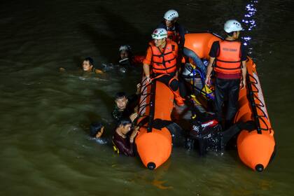 Rescatistas buscan a víctimas de un naufragio en un río en Ciamis, Java Occidental, Indonesia, el 15 de octubre de 2021. (AP Foto/Yopi Andrias)