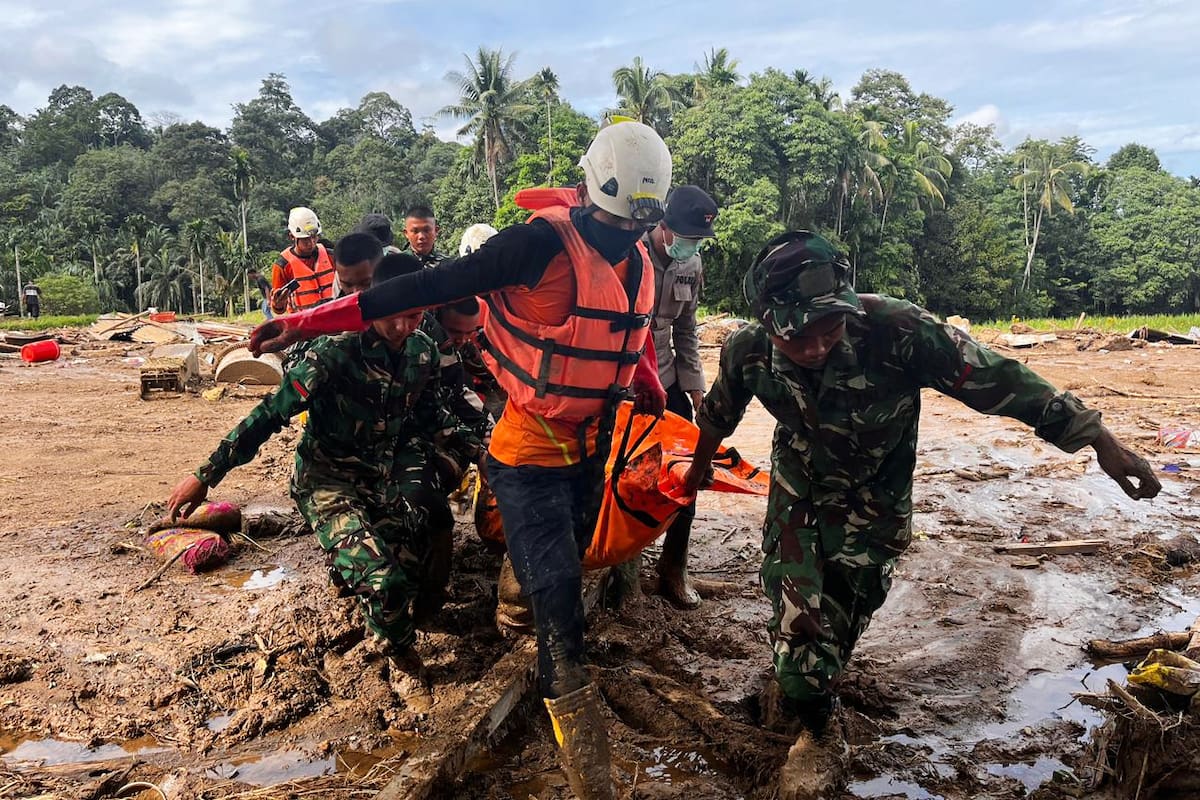 Rescatistas cargan el cuerpo de una víctima de inundaciones en Agam, Sumatra Occidental, Indonesia, el domingo 30 de noviembre de 2025