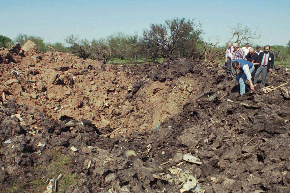 Rescatistas inspeccionan el cráter dejado por el avión al caer