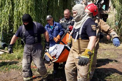 Rescatistas trasladan el cuerpo de una mujer asesinada en un ataque ruso el 25 de julio en Chuhuiv, en la región de Járkiv, Ucrania, el 26 de julio de 2022. (AP Foto/Andrii Marienko)