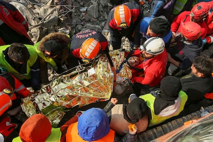 Rescatistas turcos llevan a Eyup Ak, de 60 años, a una ambulancia tras sacarlo con vida de un edificio derrumbado, 104 horas después del terremoto, en Adiyaman, el viernes 10 de febrero de 2023.