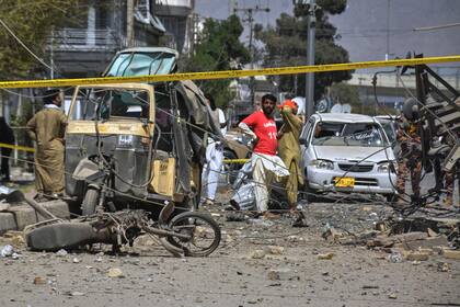 Rescatistas y agentes de seguridad examinan vehículos dañados en el lugar donde estalló el potente coche bomba en Quetta, Pakistán