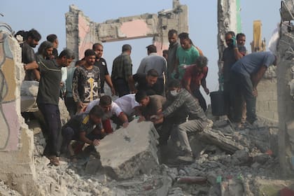 Rescatistas y residentes buscan entre los escombros luego de lo que funcionarios iraníes dijeron fue un ataque de Estados Unidos e Israel contra una escuela primaria de niñas, el sábado 28 de febrero de 2026, en Minab, Irán. (Abbas Zakeri/Agencia de Noticias Mehr vía AP)