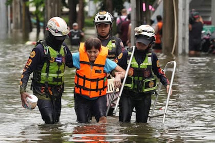 Rescuers evacuate a patient from a flooded area to a safer place after heavy rain in Bangkok, Thailand, Sunday, Sept. 27, 2026. (AP Photo/Sakchai Lalit)