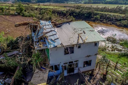 Residentes caminan entre viviendas destrozadas por inundaciones causadas por un ciclón en Mucum, en el estado de Rio Grande do Sul, Brasil, el miércoles 6 de septiembre de 2023. (AP Foto/Wesley Santos)