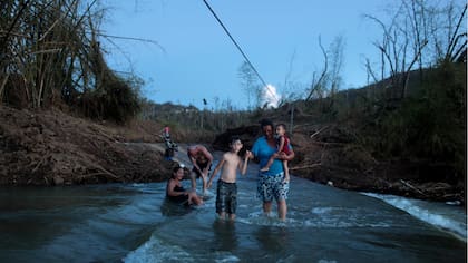 Residentes de San Lorenzo deben cruzar el río como pueden , luego del paso del Huracán Maria destruyera el puente .