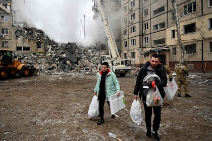 Residentes de una zona residencial de Dnipro rescatan sus enseres tras un ataque ruso